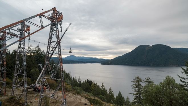 Detonation specialists work with a BC Hydro power line technician to secure the detonation device on the third and final conductor.  Detonation specialists work with a BC Hydro power line technician to secure the detonation device on the third and final conductor.