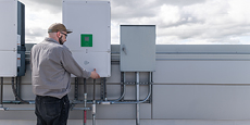 Photo of a man opening a panel on an energy storage system