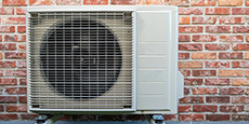 Heat pump on the wall of a brick home