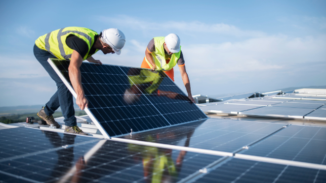 Two contractors installing solar panels