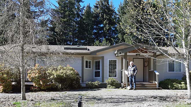 Rick Ring stands outside the manufactured home in Qualicum he shares with his wife Sue. 