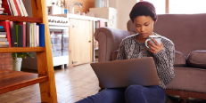 Image of woman drinking coffee and sitting with a laptop