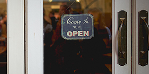 Close-up on a open sign hanging on the door of a store