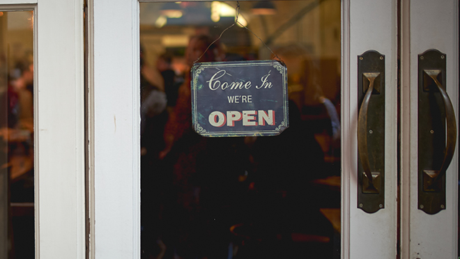 Close-up on a open sign hanging on the door of a store