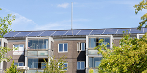 A solar panel array on the roof of a building with the sky in the background