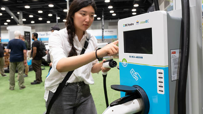 Person checking the BC Hydro Level 2 charger at 2024 Everything Electric show at Vancouver Convention Center.