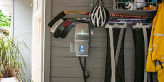 An illuminated EV charger inside a home garage.