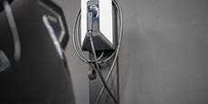 Electric vehicle charger plug on gray wall