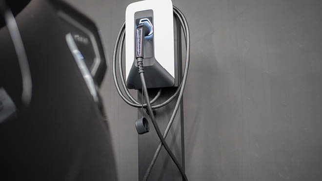 Electric vehicle charger plug on gray wall