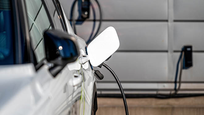 Modern electric car charging the battery inside a home garage.