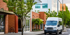 Mini van parked in front of a building.