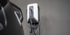 Electric vehicle charger plug on gray wall