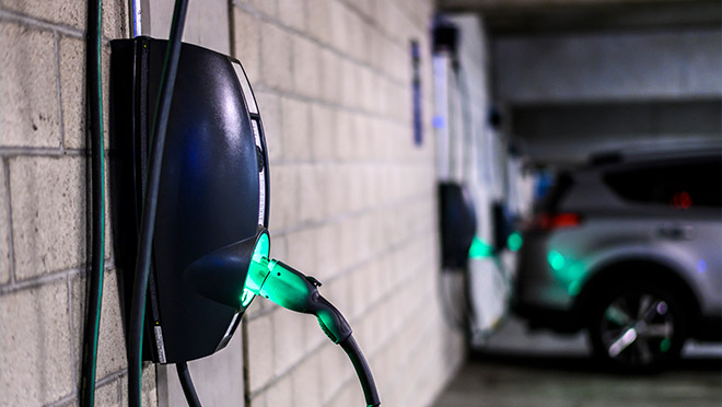 An EV charger on a parking garage wall