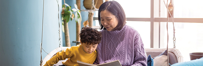 Mother and son are reading in the living room