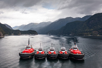 Five Haisea tug boats positioned side-by-side on a lake